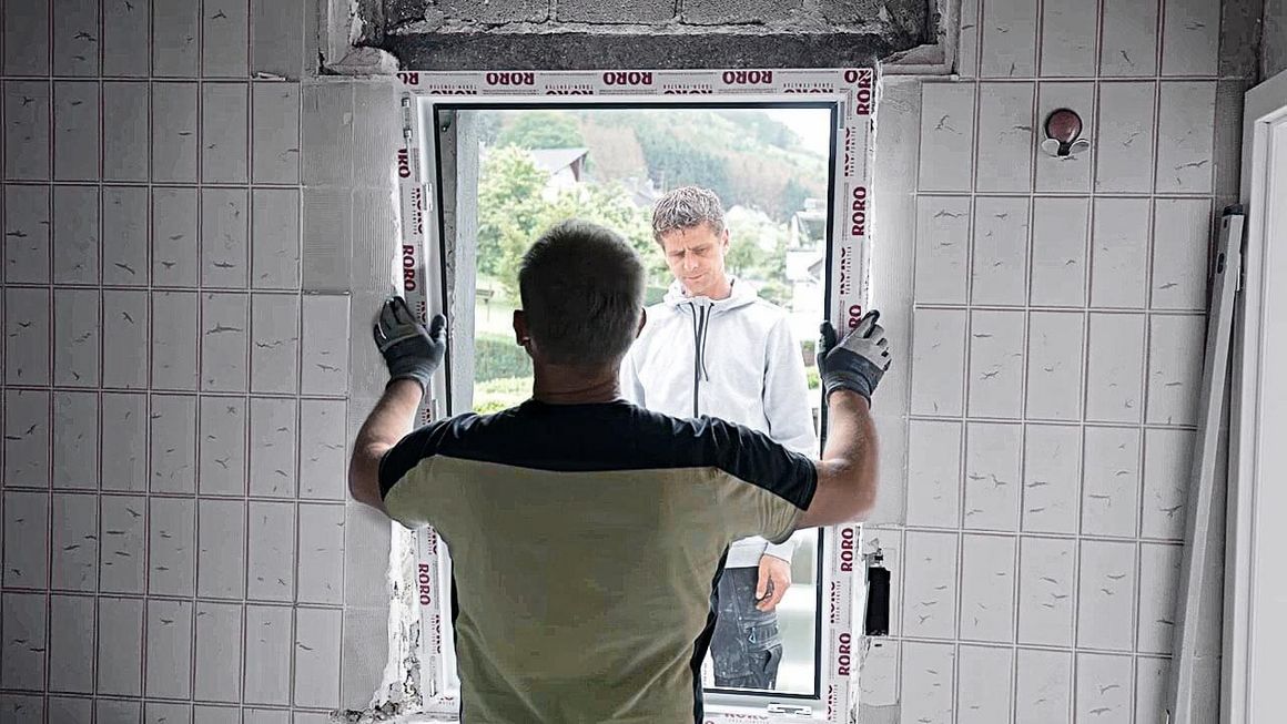Handwerker beim Einbauen eines Fensters.